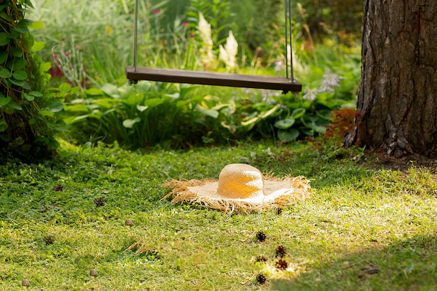 Cappello di paglia su oscillazione su verde naturale.