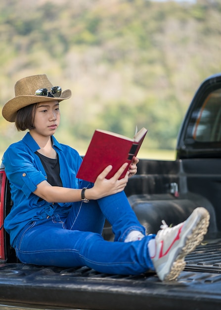 Cappello di usura della donna e leggere il libro sul camioncino