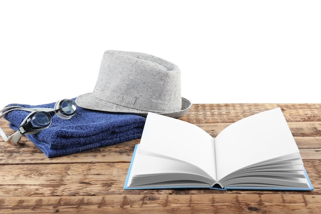 Cappello e asciugamano del libro aperto sulla tavola di legno