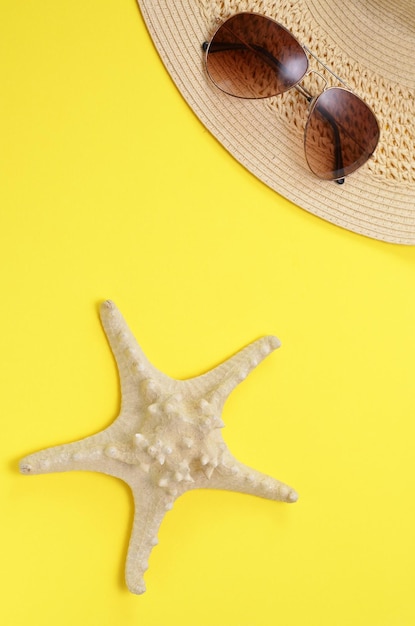 Cappello e occhiali da sole luminosi della stella marina del fondo di estate su un giallo