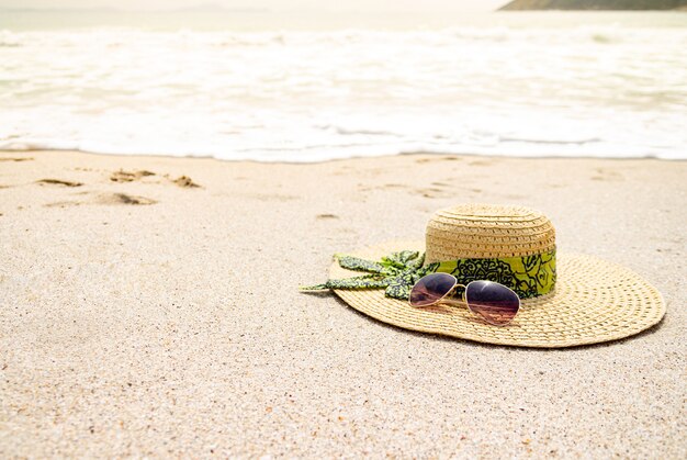 Cappello e occhiali da sole sulla spiaggia di sabbia