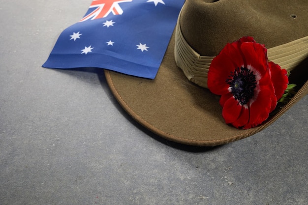 Cappello floscio dell'esercito Anzac con bandiera australiana e papavero su sfondo di pietra