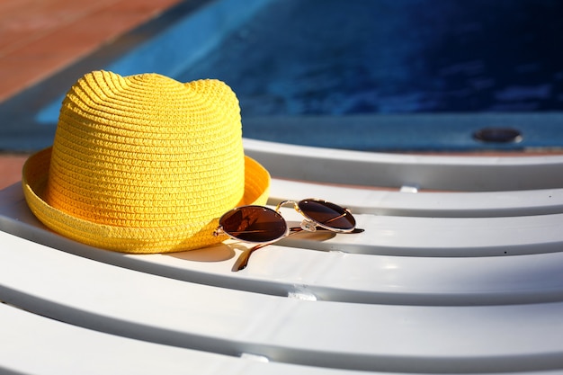 Cappello giallo e occhiali da sole su un lettino