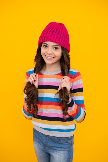 Cappello invernale Concetto di stagione fredda Accessorio moda invernale per bambini Ragazza teenager che indossa un caldo cappello lavorato a maglia Adolescente felice emozioni positive e sorridenti della ragazza adolescente