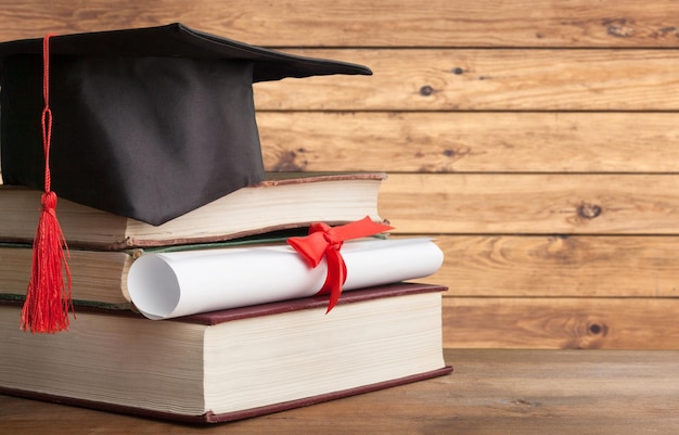 Cappello laurea nero con diploma e libro