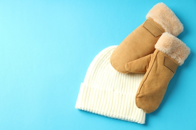 Cappello lavorato a maglia e guanti su sfondo blu.