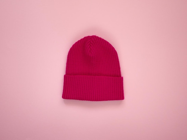 Cappello per bambini lavorato a maglia dai colori vivaci. Abbigliamento moda per bambini autunnali di mezza stagione. Vista dall'alto su sfondo rosa