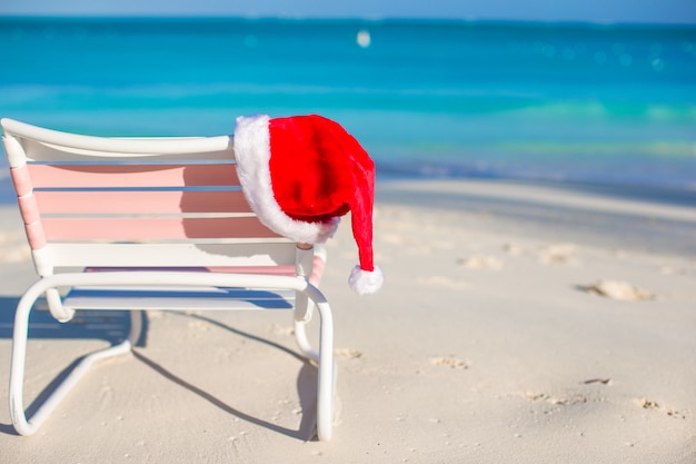 Cappello rosso di Santa sulla sedia di spiaggia