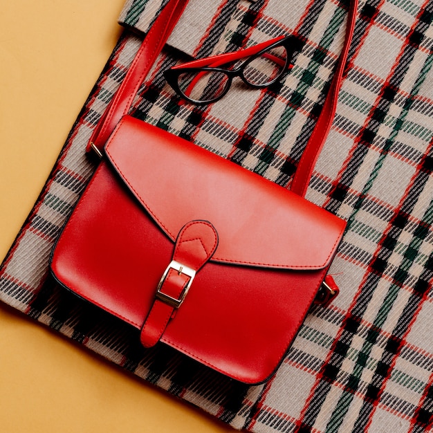 Cappotto a scacchi e accessori rossi. Borsa Rossa. Stile urbano alla moda alla moda