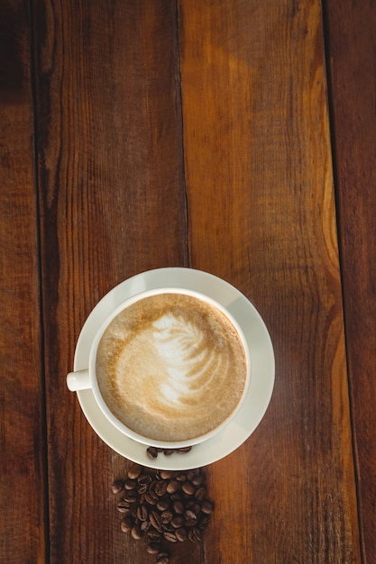 Cappuccino con chicchi di caffè sul tavolo