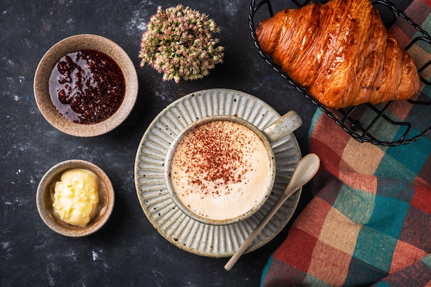 Cappuccino con cornetto sul tavolo