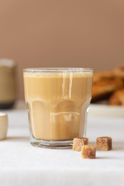 Cappuccino di caffè fresco in un bicchiere con zucchero sul tavolo