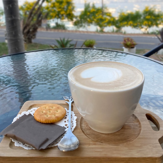 Cappuccino di caffè sul tavolo di vetro nella caffetteria all'aperto