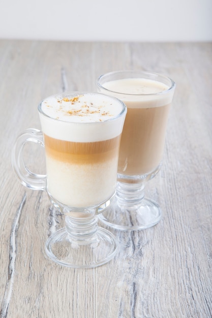 cappuccino di latte in un bicchiere trasparente su uno sfondo di barattolo