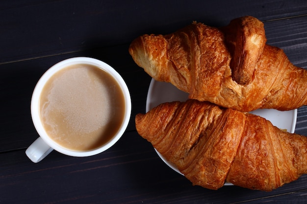 Cappuccino e croissant su un buio