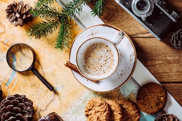 Cappuccino su un tavolo di legno, mappa turistica e macchina fotografica.