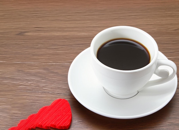 cappuccio di caffè con un cuore sul piatto con la torta