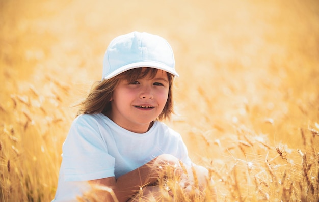 Capretto al campo di grano Ragazzino bambino su un campo di grano alla luce del sole per godersi la natura