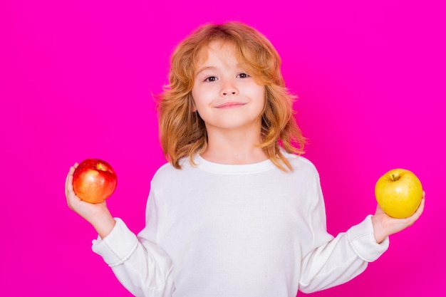 Capretto con mela in studio Studio ritratto di bambino carino tenere mela isolata su sfondo rosa