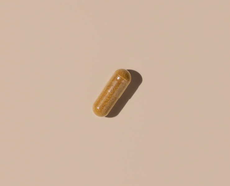 Foto capsula medica marrone su ombre dure vista dall'alto beige chiaro assunzione di integratori alimentari