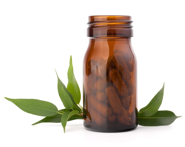 Capsule di farmaci a base di erbe in bottiglia di vetro marrone isolate su sfondo bianco ritaglio Concetto di medicina alternativa