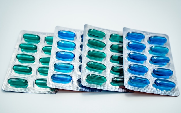 Capsule di gelatina molli blu e verdi in blister su fondo bianco. Capsula di ibuprofene e naprossene. Medicina per antinfiammatori, analgesici. Antidolorifico. Industria farmaceutica.