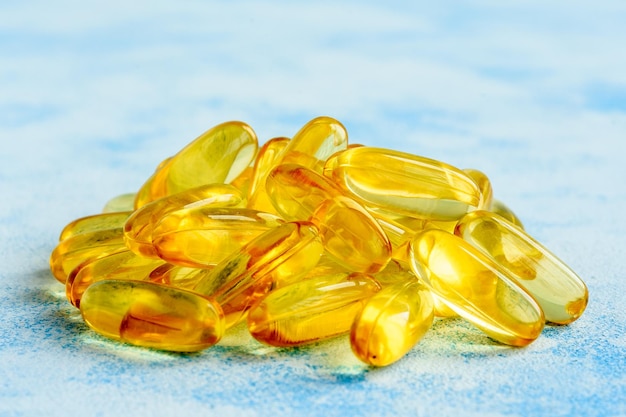 Capsule di olio di pesce su sfondo blu vitamine omega 3 e concetto di salute