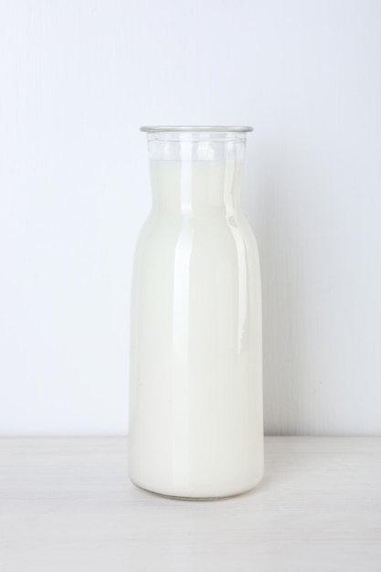 Caraffa di vetro di latte fresco su un tavolo di legno