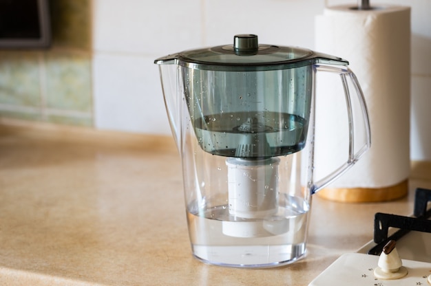 Caraffa filtrante per l'acqua sul tavolo della cucina. Concetto di acqua pulita. Acqua di filtrazione.