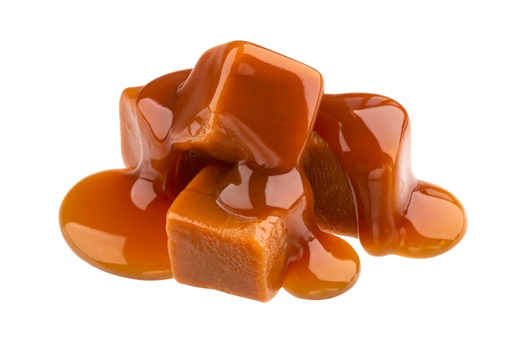 Foto caramelle al caramello e salsa al caramello isolato su bianco