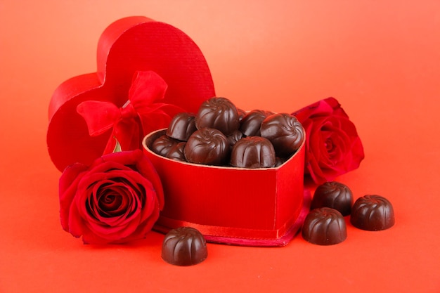 Caramelle al cioccolato in confezione regalo, su sfondo rosso