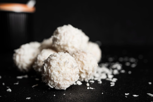 Caramelle al cocco con noci su sfondo scuro Raffaello su sfondo nero Foto di alta qualità