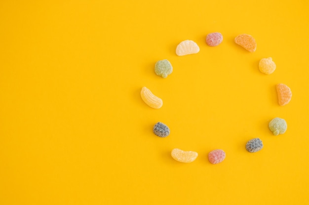 Caramelle alla frutta color gelatina su sfondo giallo