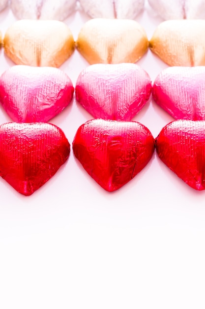 Caramelle di cioccolato a forma di cuore avvolte in un foglio colorato per San Valentino.