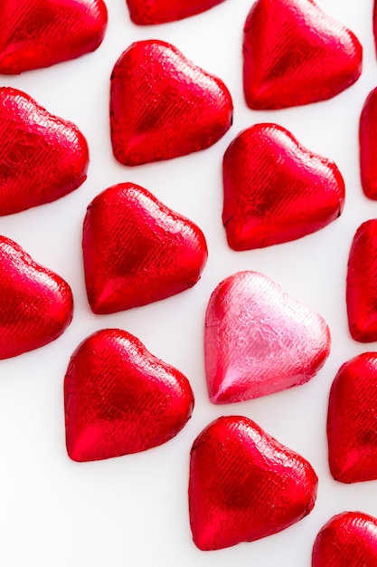 Caramelle di cioccolato a forma di cuore avvolte in un foglio rosso per San Valentino.