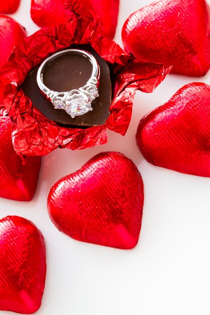 Caramelle di cioccolato a forma di cuore avvolte in un foglio rosso per San Valentino.