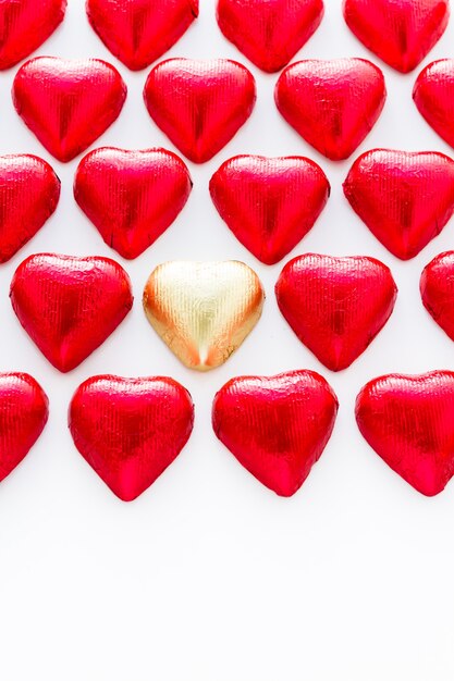 Caramelle di cioccolato a forma di cuore avvolte in un foglio rosso per San Valentino.