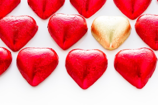 Caramelle di cioccolato a forma di cuore avvolte in un foglio rosso per San Valentino.