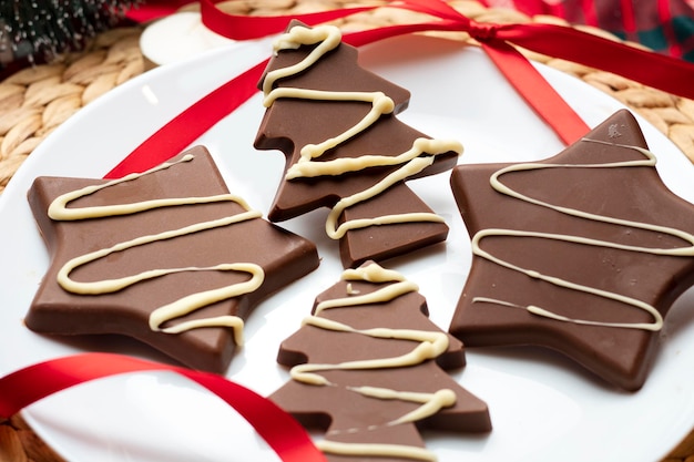 Caramelle di cioccolato di Natale su un piatto bianco circondato da un nastro rosso