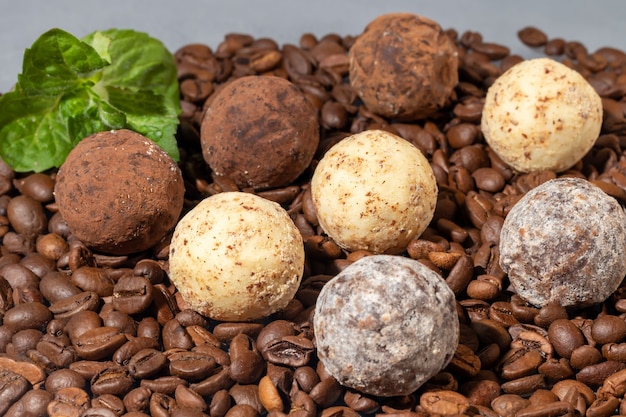 Caramelle di cioccolato su una superficie grigia con la riflessione. Farcitura di noci e frutta. Copia spazio.