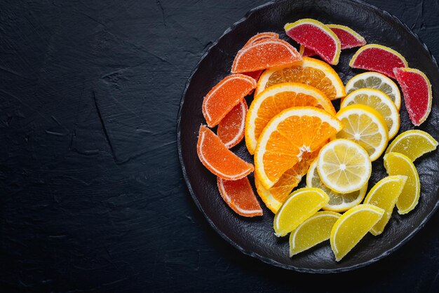 Caramelle di gelatina di marmellata multicolore e pezzi di arancia e limone