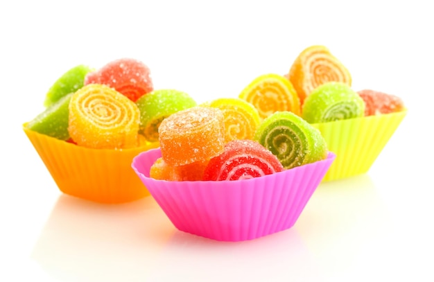 Caramelle di gelatina dolci in casi di torta di tazza isolati su bianco