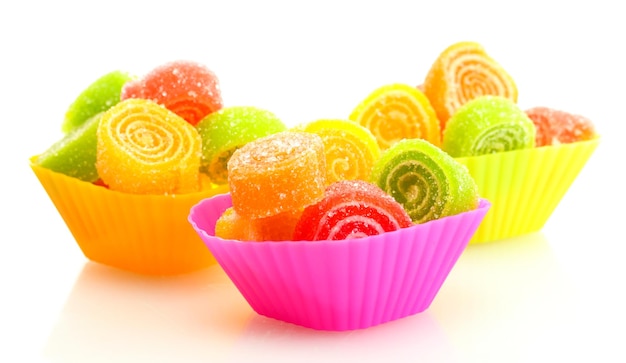 Caramelle di gelatina dolci in casi di torta di tazza isolati su bianco