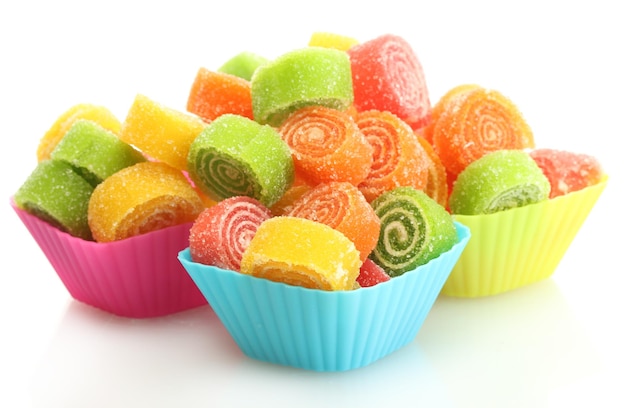 Caramelle di gelatina dolci in casi di torta di tazza isolati su bianco