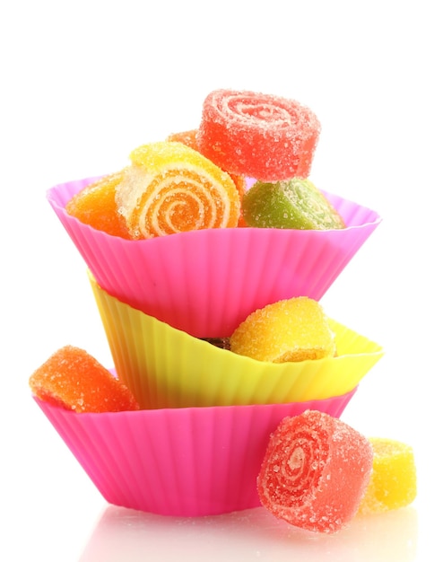 Caramelle di gelatina dolci in casi di torta di tazza isolati su bianco