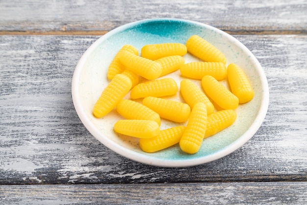 Caramelle di mais gelatina su fondo di legno grigio