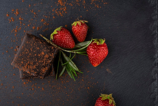 Caramelle dolci cosparse di cacao e accanto alle fragole. Delizioso dolce. Latte d'uccello al cioccolato