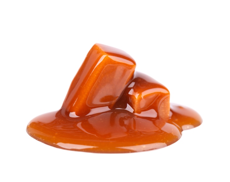 Foto caramelle dolci e salsa del caramello, isolate su bianco. caramello delizioso
