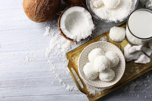 Caramelle fatte in casa in scaglie di cocco e cocco fresco su sfondo chiaro