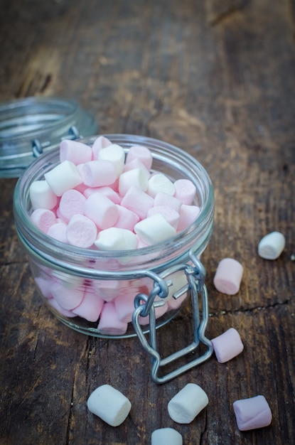 Caramelle gommosa e molle bianche e rosa in un barattolo